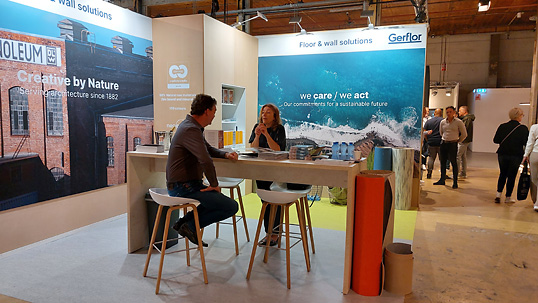 Stand van Gerflor, met inbegrip van DLW Linoleum. Aan tafel is Esther de Jong (rechts) in gesprek met een klant. Stand van Gerflor
